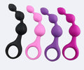 Four silicone butt plugs in black, pink, purple, and magenta on a white background