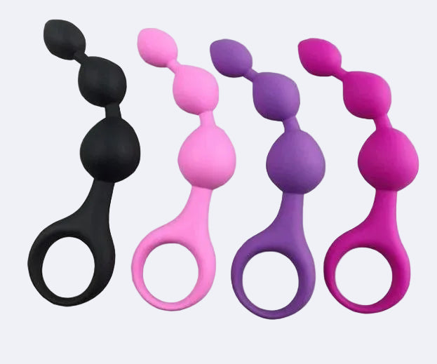 Four silicone butt plugs in black, pink, purple, and magenta on a white background